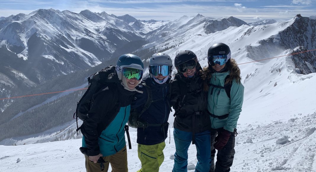 four women with colorado peaks behind them in winter