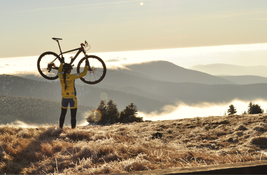 women holding a mountain bike over her head