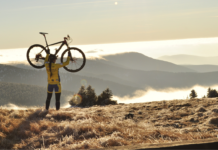 Best Women’s Full Suspension Mountain Bikes women holding a mountain bike over her head