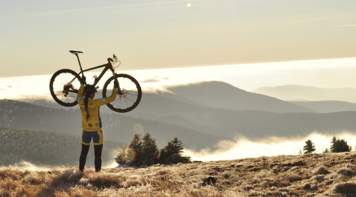 Best Women’s Full Suspension Mountain Bikes women holding a mountain bike over her head